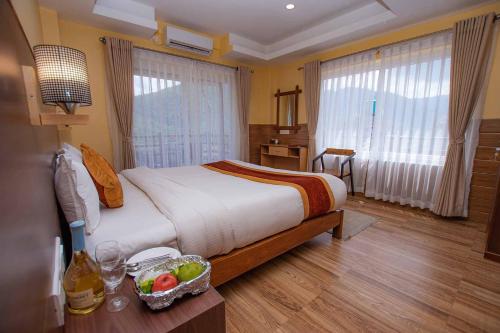 a bedroom with a bed with a bowl of fruit on a table at Hotel Hidden Kingdom in Pokhara