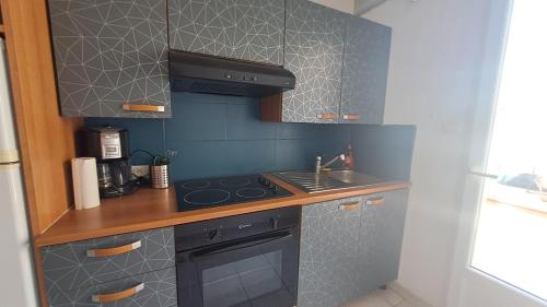 Il comprend une petite cuisine équipée d'une cuisinière et d'un évier. dans l'établissement Studio duplex avec extérieur, à Aigues-Mortes