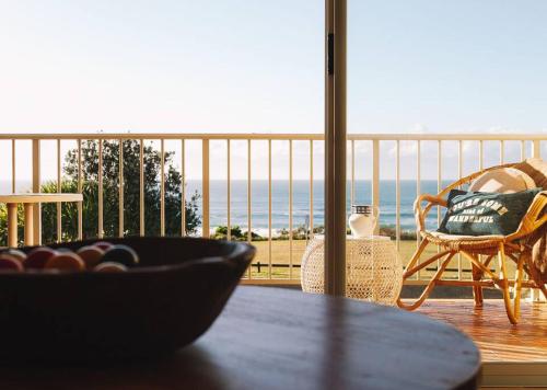 a table with a view of the ocean from a balcony at Ocean View Pippi Beach Yamba in Yamba