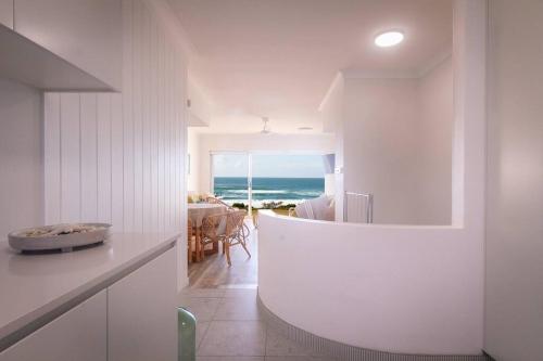 a kitchen and dining room with a view of the ocean at Ocean View Pippi Beach Yamba in Yamba