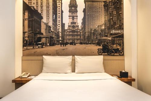 a bed with a picture of a city at Feodora Hotel in Jakarta