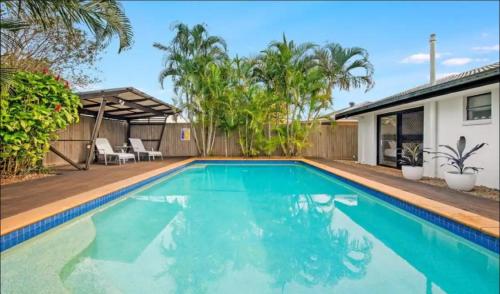 a swimming pool in front of a house at Cool Cabana Mermaid Beach in Gold Coast