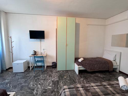 a bedroom with a bed and a table with a television at Mestre Residence in Mestre