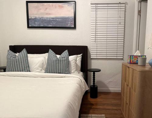 Un dormitorio con una cama blanca con almohadas y una ventana. en Modern Eclectic 1BR by Downtown, Airport & More, en San Diego