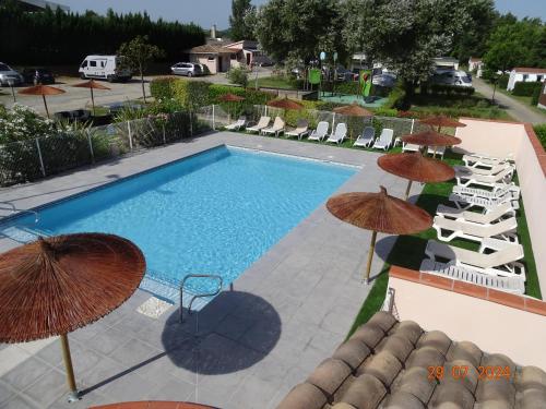 an overhead view of a swimming pool with umbrellas at Camping Les Nysades in Mirepoix