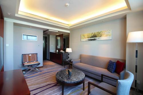 a living room with a couch and a tv at Swiss Grand Xiamen-Harbour View in Xiamen