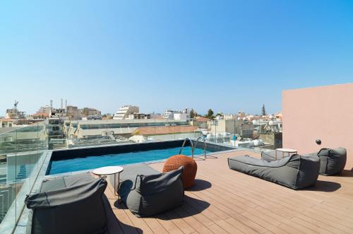 a patio with chairs and a pool on top of a building at Alinea Market Agora Square in Limassol