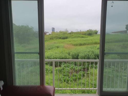 an open window with a view of a field at ゴルフ-villa-北広島輪厚 in Ōmagari