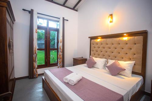 a bedroom with a large bed with two towels on it at 2BR Family Getaway Hikkaduwa- Sleep 6 - Surfing- Bikes and airport drop-off in Hikkaduwa