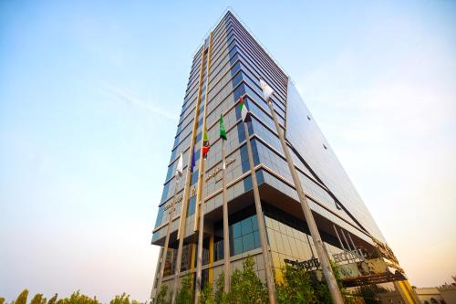 a tall glass building with a lot of windows at Grand Villaggio Hotel Abu Dhabi in Abu Dhabi