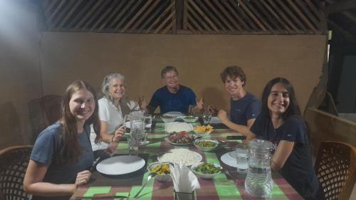 a group of people sitting around a table with food at Wild View Stay in Habarana