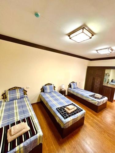 a bedroom with two beds in a room at Muhtasham in Bukhara