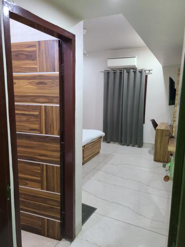 a door leading into a room with a bed and a shower at Pinnacle Hotel in Phagwāra