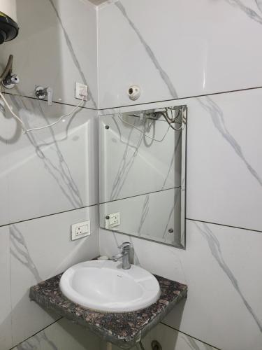 a bathroom with a sink and a mirror at Pinnacle Hotel in Phagwāra