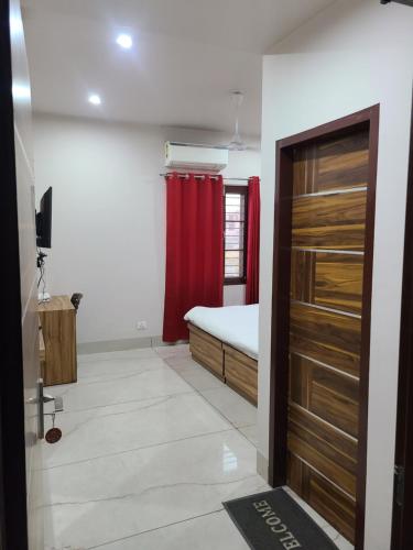 a bedroom with a bed and a red curtain at Pinnacle Hotel in Phagwāra