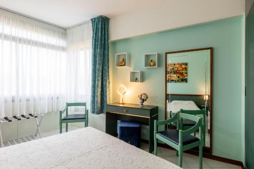 a bedroom with a mirror and a desk and chair at Casa Vacanza Marina di Pietrasanta in Pietrasanta