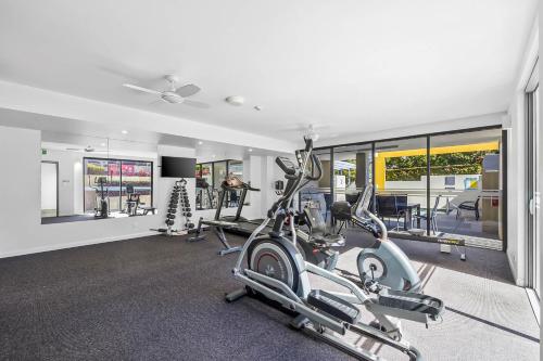 a gym with several treadmills and elliptical machines at Nova Mooloolaba Beach Apartments in Mooloolaba