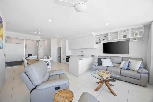 a living room with two couches and a kitchen at Nova Mooloolaba Beach Apartments in Mooloolaba