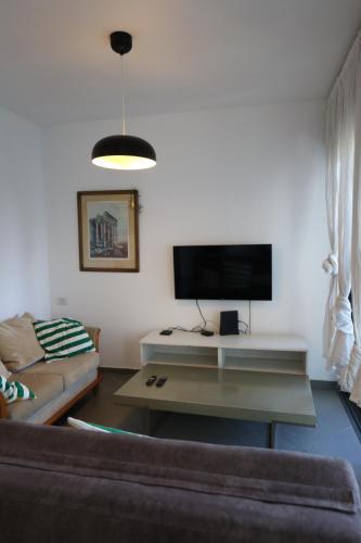 a living room with a couch and a flat screen tv at Assuta family in Tel Aviv