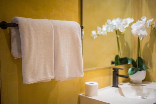 a bathroom with white towels and a sink with a mirror at Tegal Wangi Canggu in Canggu