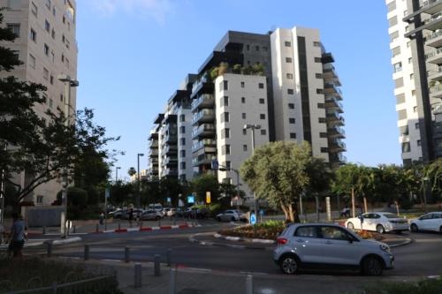a car parked in a parking lot with tall buildings at Assuta family in Tel Aviv