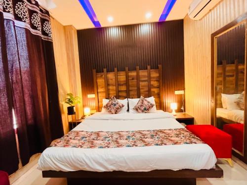 a bedroom with a large bed and a red chair at Hotel Pearl Grand-Family Hotel-Feel Like home in Zirakpur