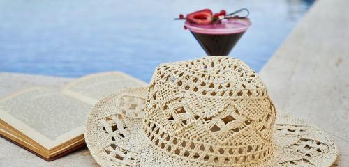 a straw hat sitting on a table next to a book at Upscale 2bd & 2ba Apt in Swara Ranch in Maiyan in Nanyuki