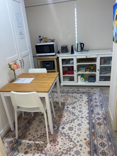 a kitchen with a wooden table and white cabinets at Hideaway on Hume in Boonah