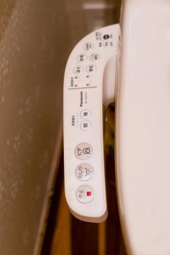 a close up of a remote control on a toilet at 都電屋 TodenHotel in Tokyo