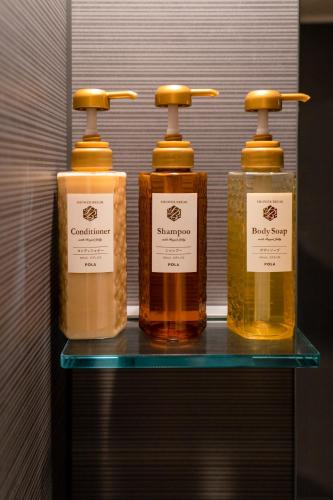 a group of four bottles of soap on a shelf at 都電屋 TodenHotel in Tokyo