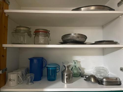 a shelf with jars and other items on it at The Local Pin House - Ευρύχωρη μονοκατοικία, Λαμία in Lamía
