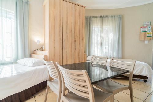a dining room with a table and chairs next to a bed at ATKV Goudini Spa in Rawsonville