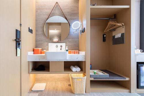 a bathroom with a sink and a mirror at Atour Hotel Shenzhen Nanshan Shili Metro Station in Shenzhen