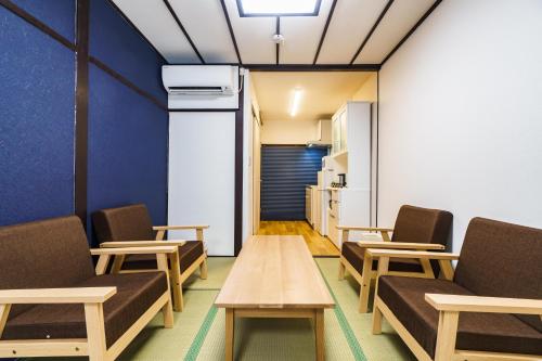 a room with chairs and a table and a refrigerator at 雅宿nf203最大6名長期滞在大歓迎最寄り駅から徒歩2分 in Osaka
