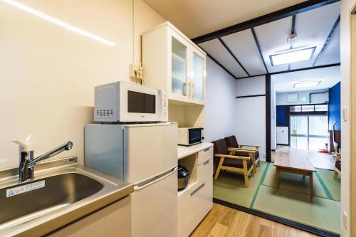 a kitchen with a sink and a microwave at 雅宿nf203最大6名長期滞在大歓迎最寄り駅から徒歩2分 in Osaka