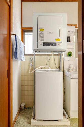 a small bathroom with a refrigerator and a microwave at 池袋駅まで徒歩15分 畳の家 in Tokyo