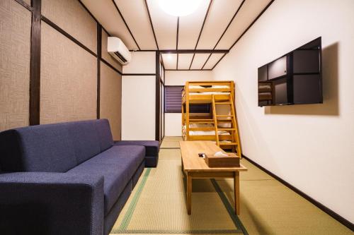 a living room with a couch and a tv at 雅宿nf203最大6名長期滞在大歓迎最寄り駅から徒歩2分 in Osaka