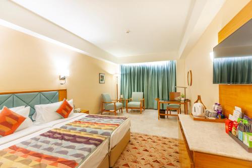a hotel room with a bed and a table and chairs at Fortune Park Lake City, Thane - Member ITC Hotels' Group in Thane