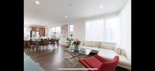 a living room with a white couch and red chairs at Costa Mesa Cozy Retreat, Modern and Smart Home in Costa Mesa
