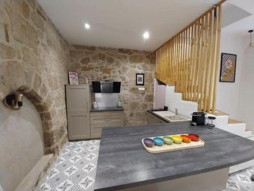 - une cuisine avec un comptoir orné de peintures dans l'établissement Maison centre historique Figeac, à Figeac