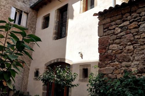 a white building with a door and a stone wall at Maison centre historique Figeac in Figeac
