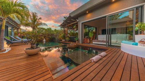 a house with a swimming pool and a wooden deck at Villa Sartelo in Tamarin
