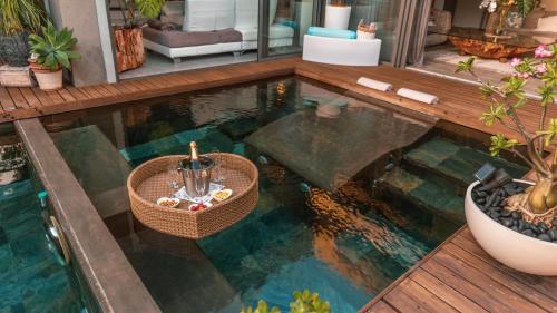 a swimming pool with a table in the water at Villa Sartelo in Tamarin