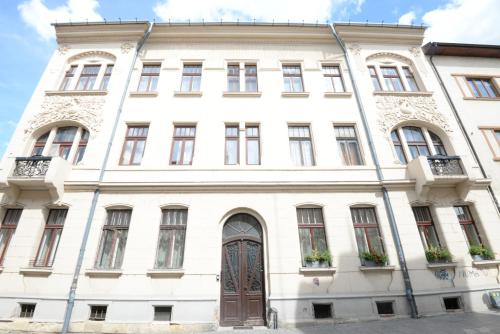 a large white building with a brown door at City Central Escape in Cluj-Napoca