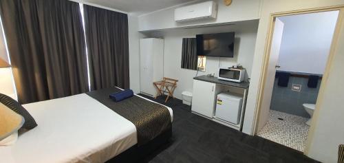 a hotel room with a bed and a microwave at Silver Oaks Motel in Gilgandra