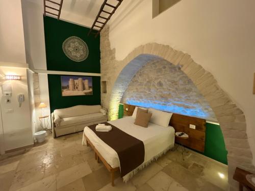 a bedroom with a bed in a room with a stone wall at Torre Pendio b&b in Corato