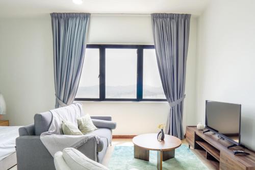 a living room with a couch and a tv at Encorp Strand Residences by Airhost in Kota Damansara