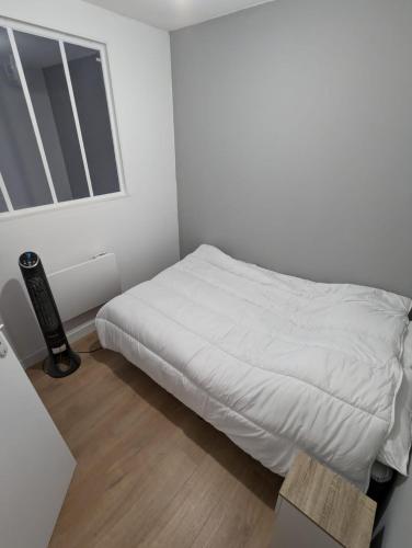 une chambre blanche avec un lit et une fenêtre dans l'établissement T1 bis de 30 m2 avec terrasse, à Toulouse