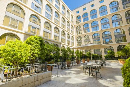a building with tables and chairs in front of a building at Grand Court Hotel in Jerusalem