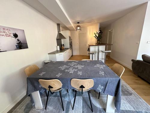 une salle à manger avec une table et des chaises bleues dans l'établissement Charmant T3 à la plage, à Seignosse